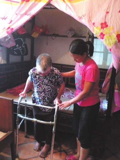 夏瓊在幫助婆婆做康復(fù)鍛煉,，經(jīng)過悉心照顧婆婆終于可以站起來了